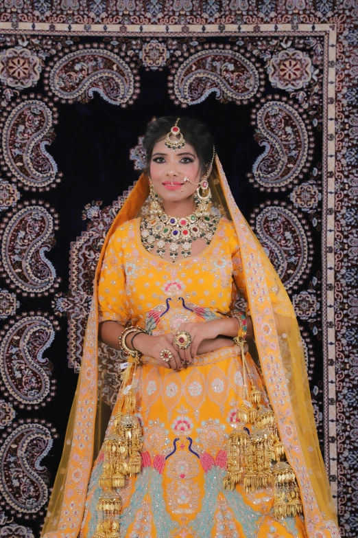 a woman in yellow and gold, is shown in traditional indian costume