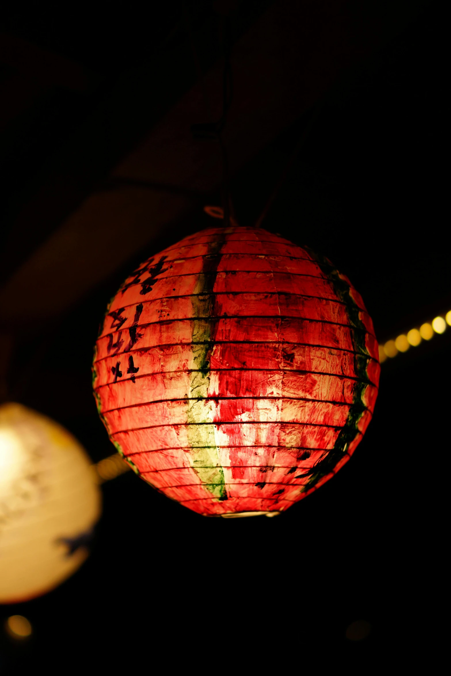 a lit chinese lantern sits on a string