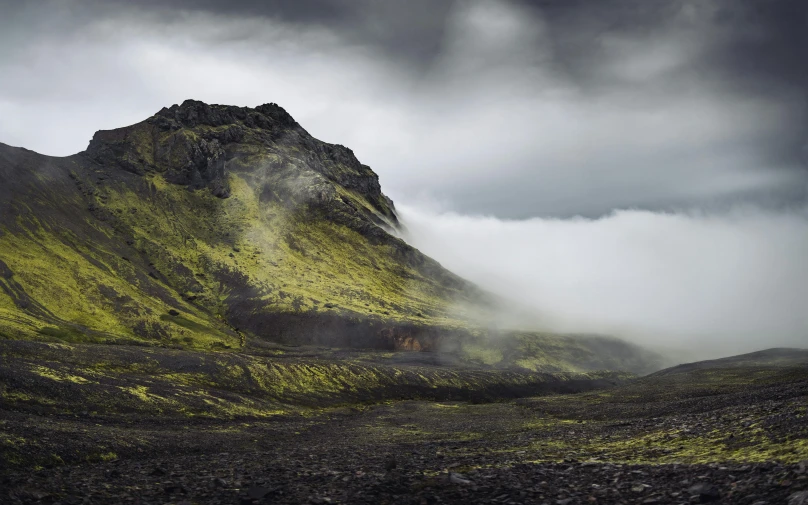 a mountain that has grass growing on it