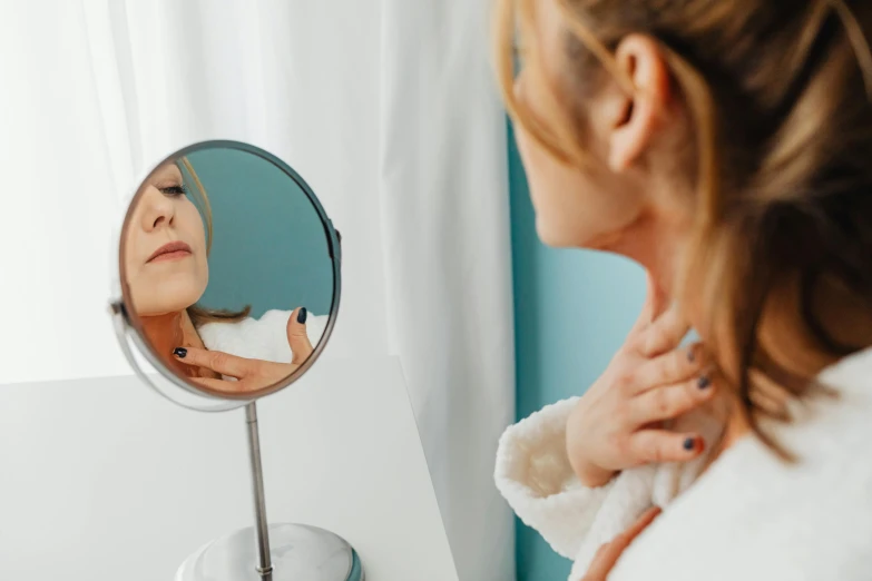 a woman brushing her teeth in front of a mirror