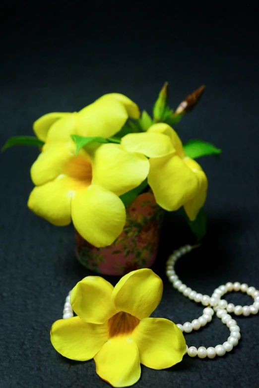 a few yellow flowers and a pearl necklace