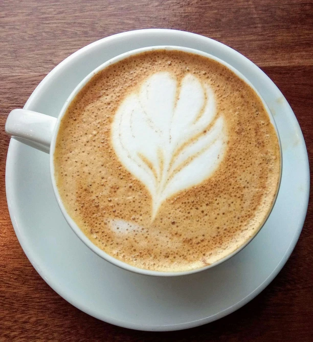 a cup of coffee sitting on top of a white plate