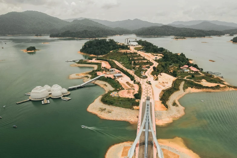 an island in the middle of a lake and a bridge above it