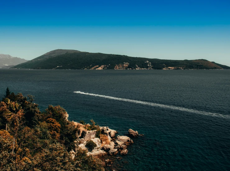 view from rocks of a lone boat on water