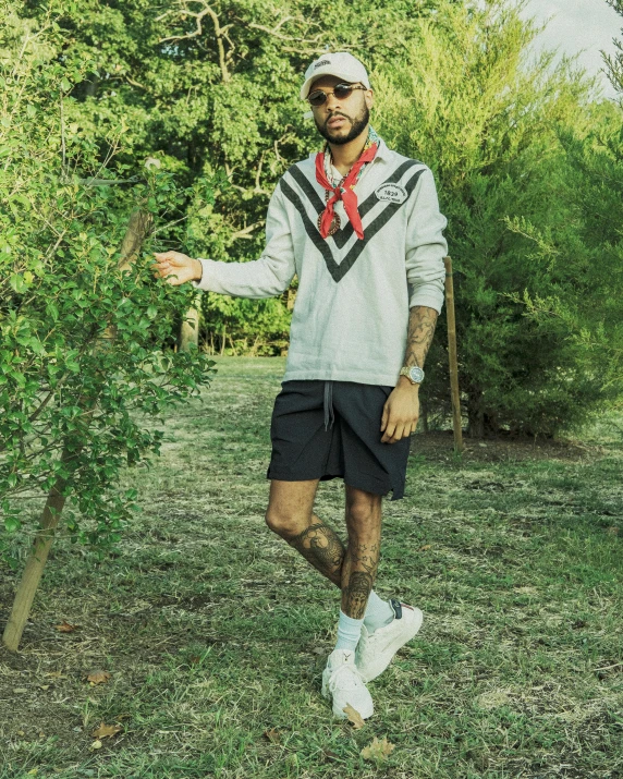 a man standing in front of some bushes and trees