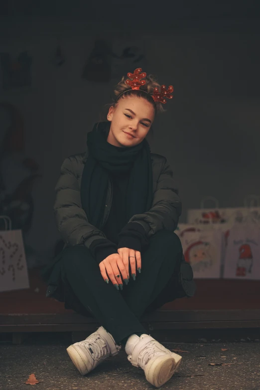 a person with an artistically designed headband is sitting on the street