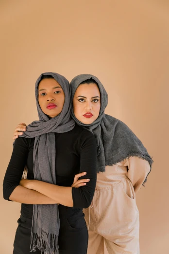 two women wearing head coverings pose for the camera