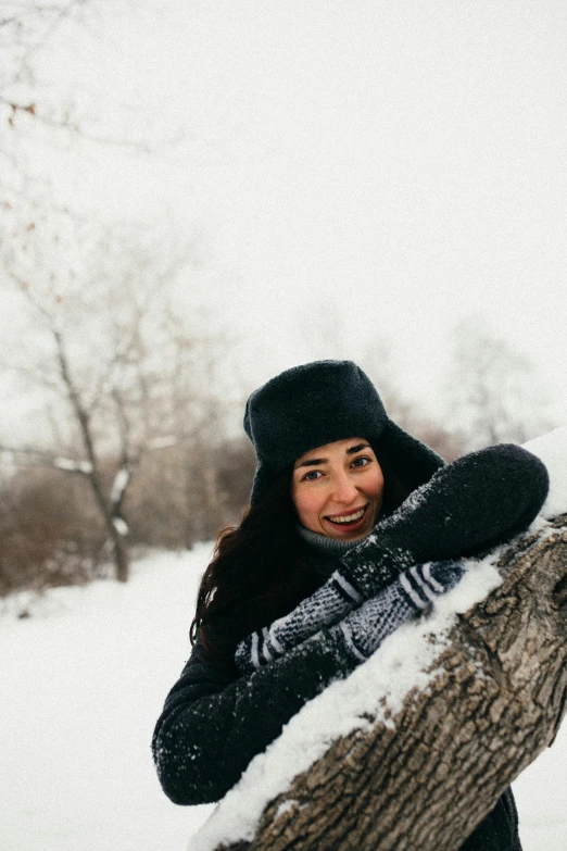 a woman holding onto a snowboard in the snow