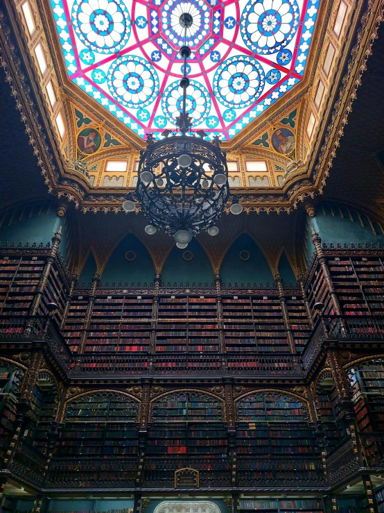 an intricately detailed ceiling inside a liry with several books