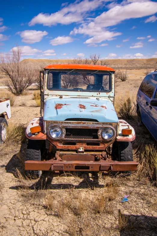 an old vehicle that is rustying in the desert