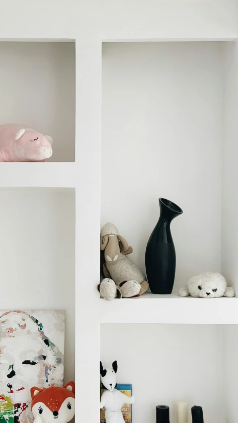 a shelf filled with dolls and books on top of them