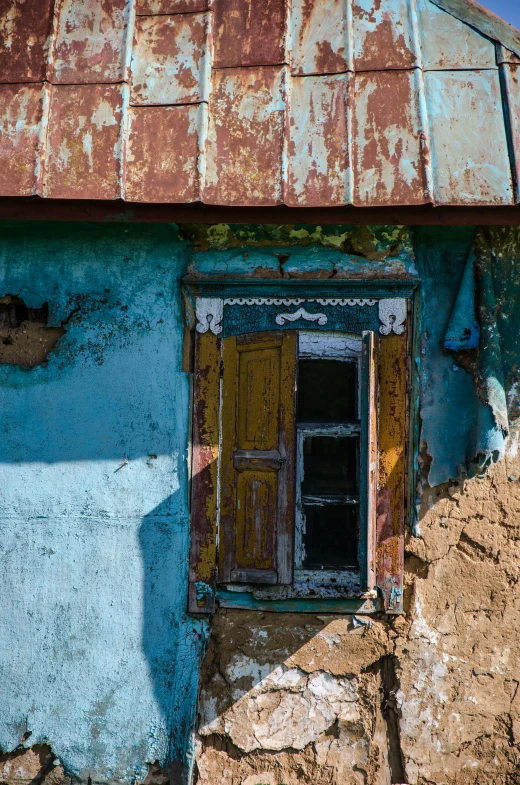 a dilapidated building with a door and windows