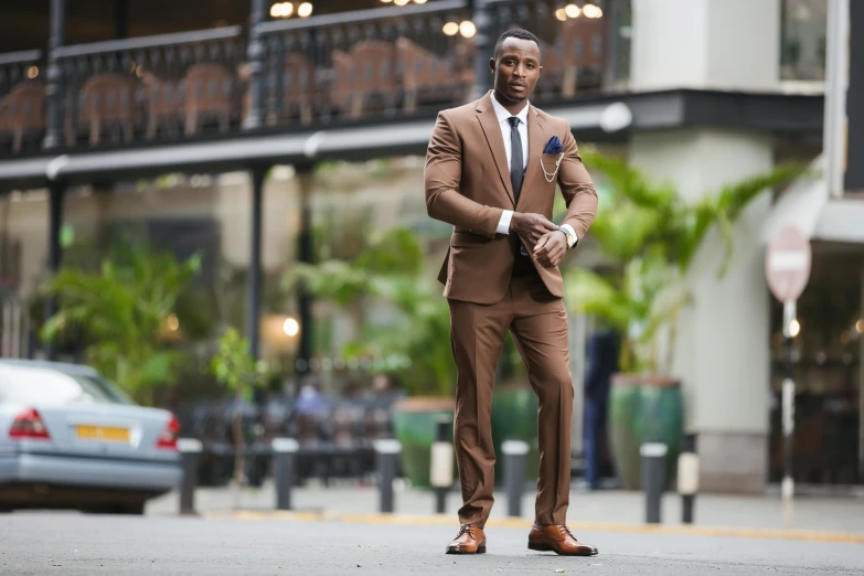 a man in a tan suit standing on the street