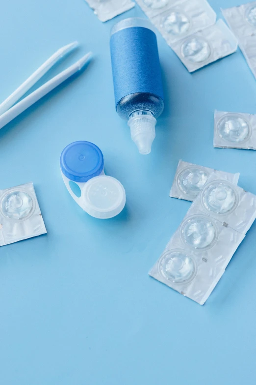 the pills and two packs of white toothpaste sitting on a blue surface