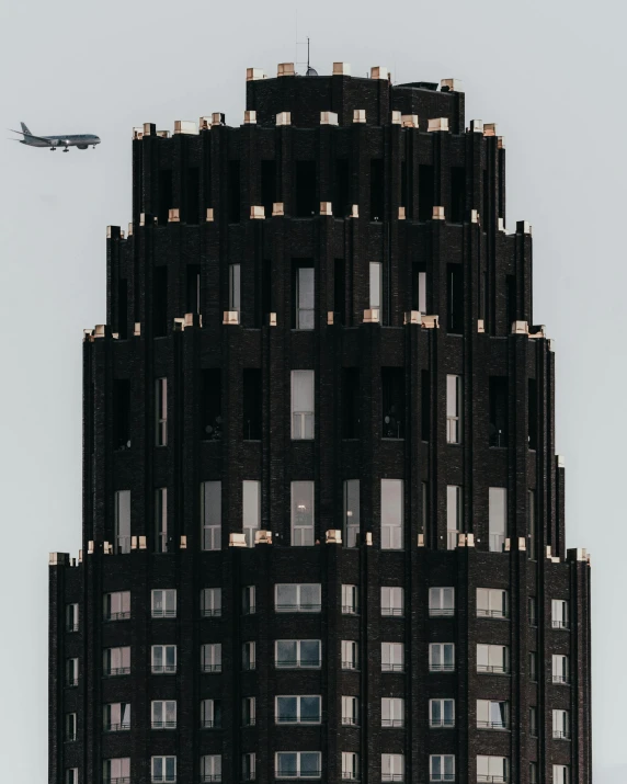 a jet flying by a tall building with lots of windows