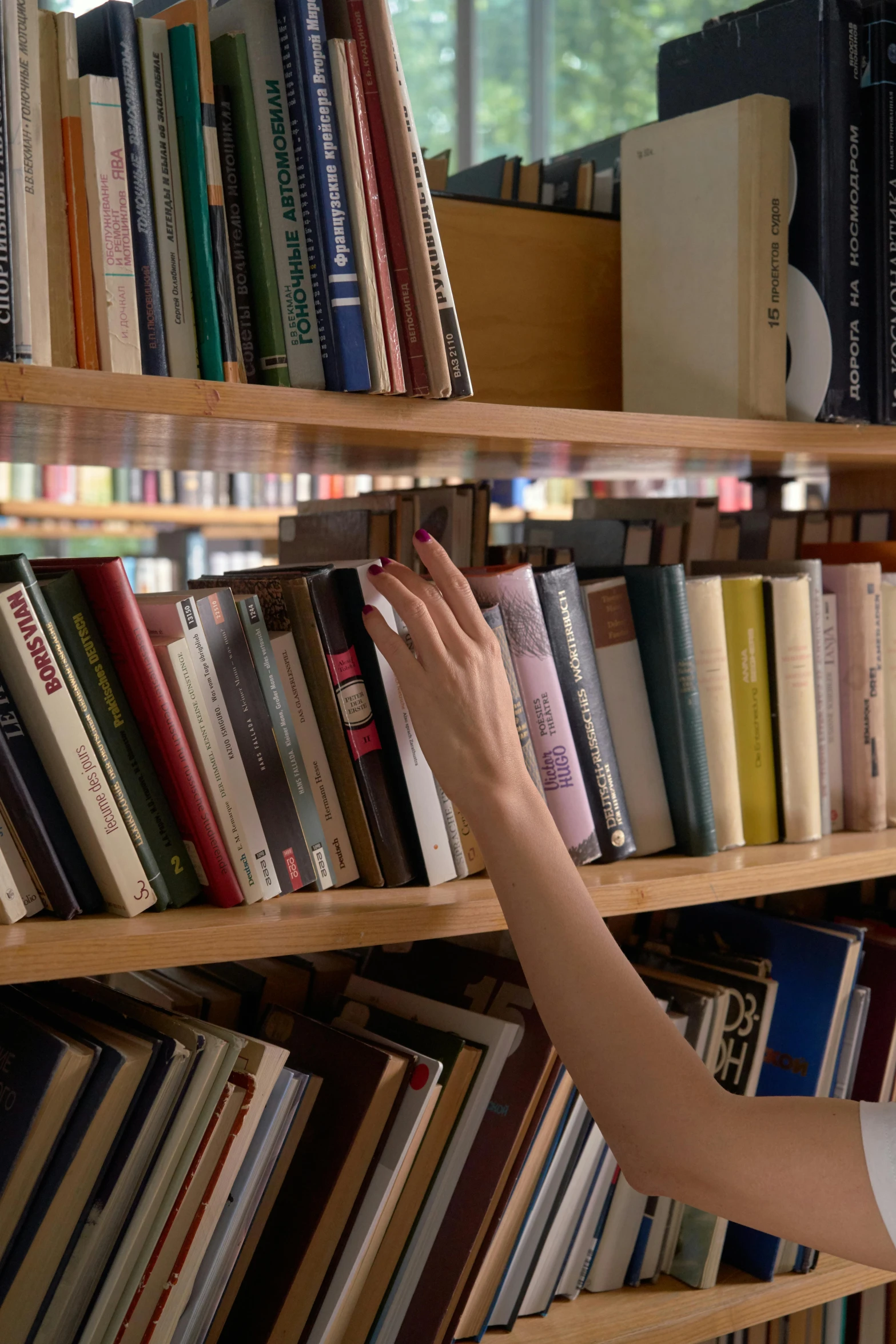  picking book from shelves filled with books