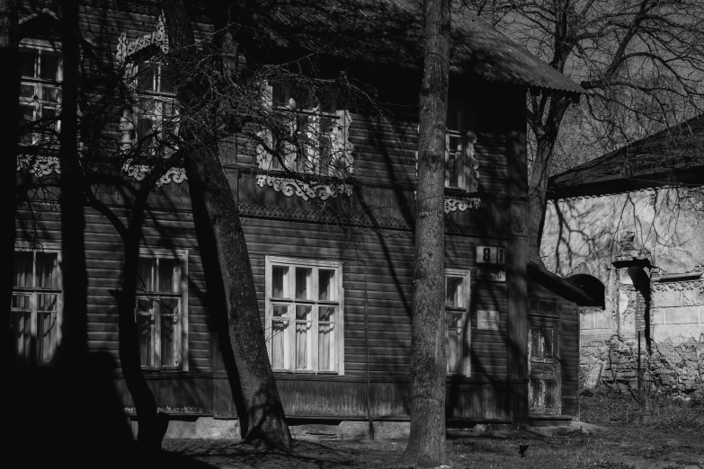 black and white pograph of an old house in the woods