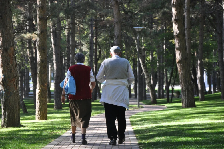 a man and a woman are walking down the sidewalk