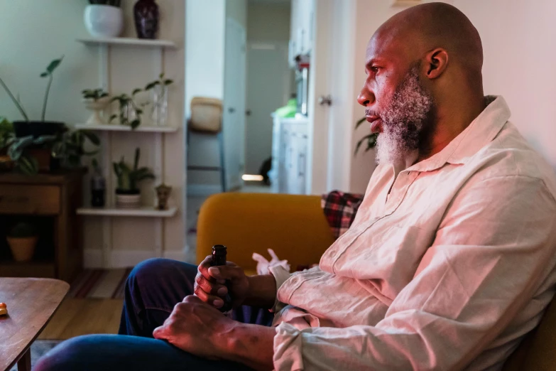 a man is sitting on a chair in his living room