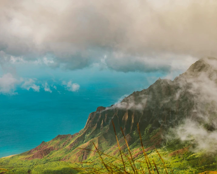 the mountains with trees and clouds over them