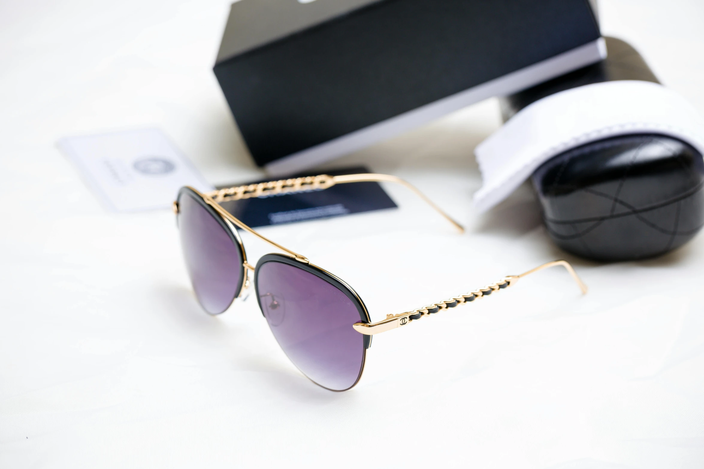 a pair of sunglasses laying on a table next to an object