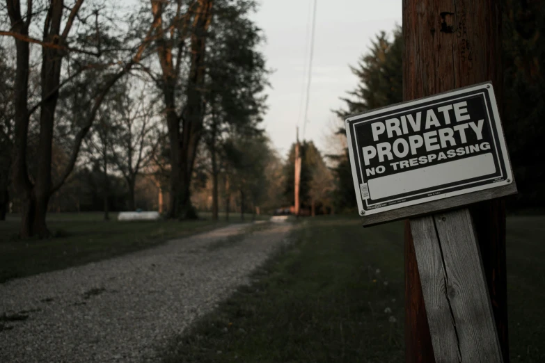 a private property sign is posted on a wooden pole