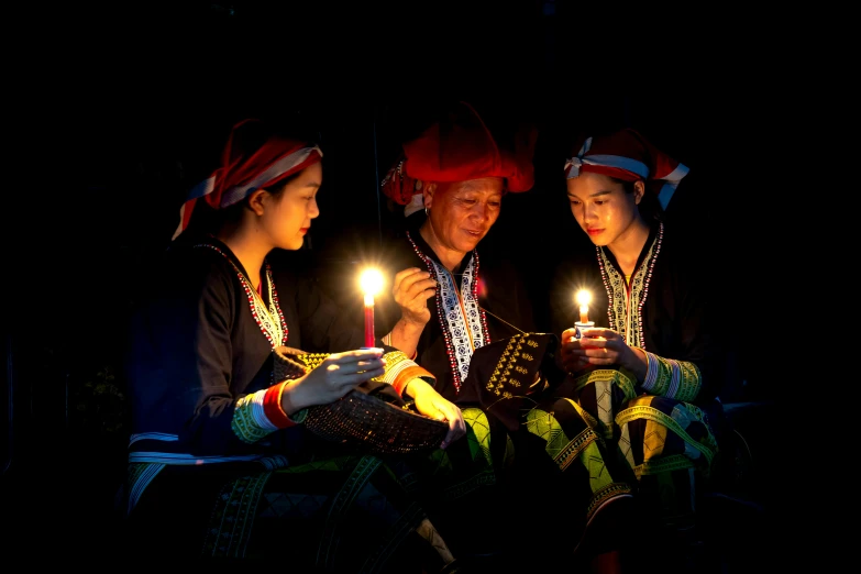 three people are lit with a candle in each hand