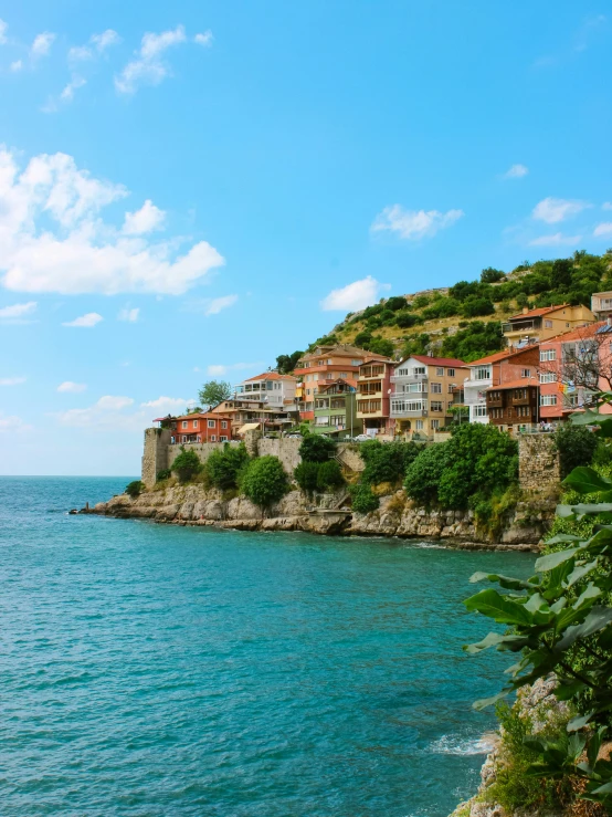 a scenic view of some houses on a hill side near the water