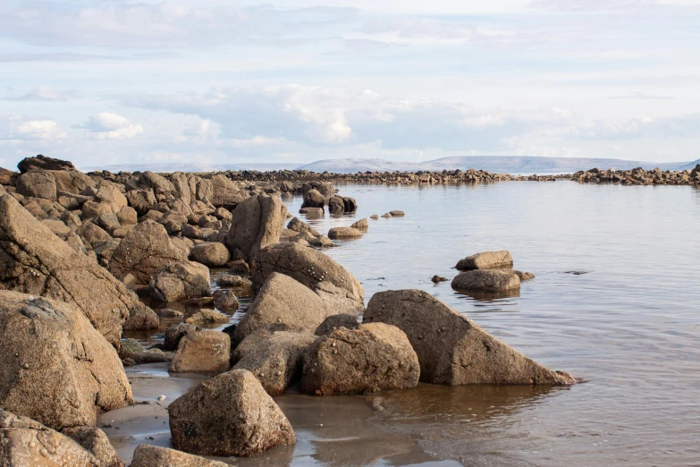 a couple of rocks sitting by the water