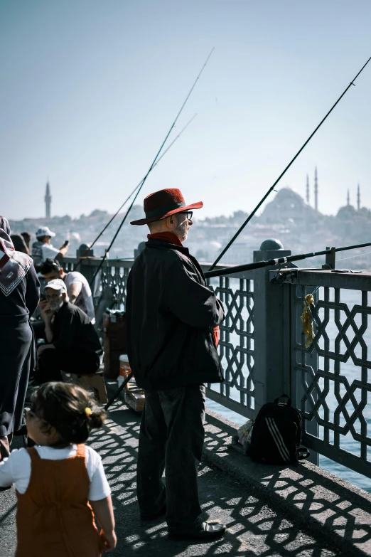 an image of a man standing on the side of a bridge fishing