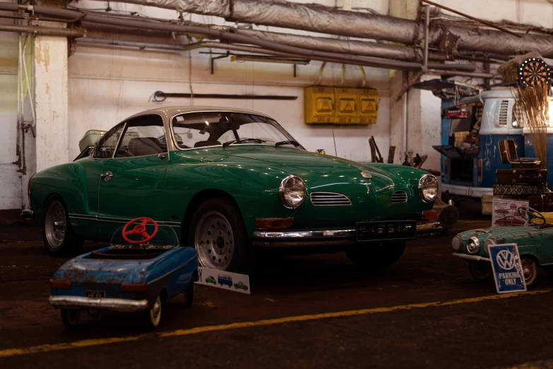 a green car parked in a garage next to other cars