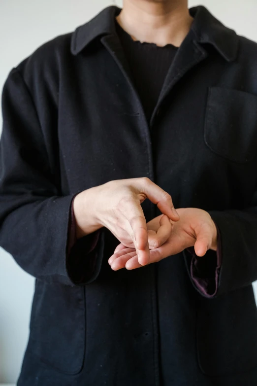 a person wearing a jacket holds their hand in the air