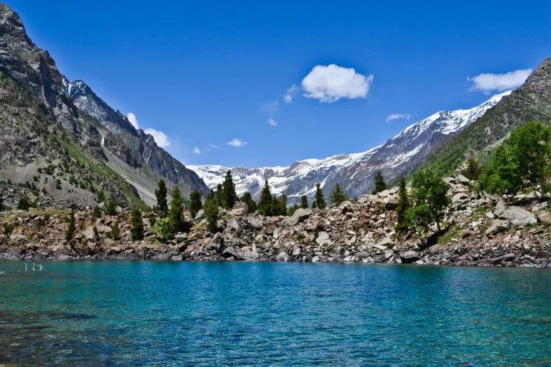 the mountains are covered in snow and surrounded by water