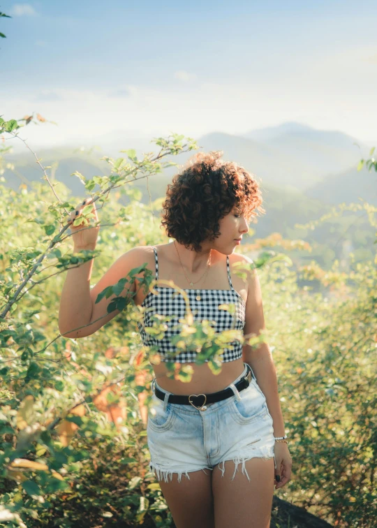 the woman is standing on the hill holding her hands up to her face