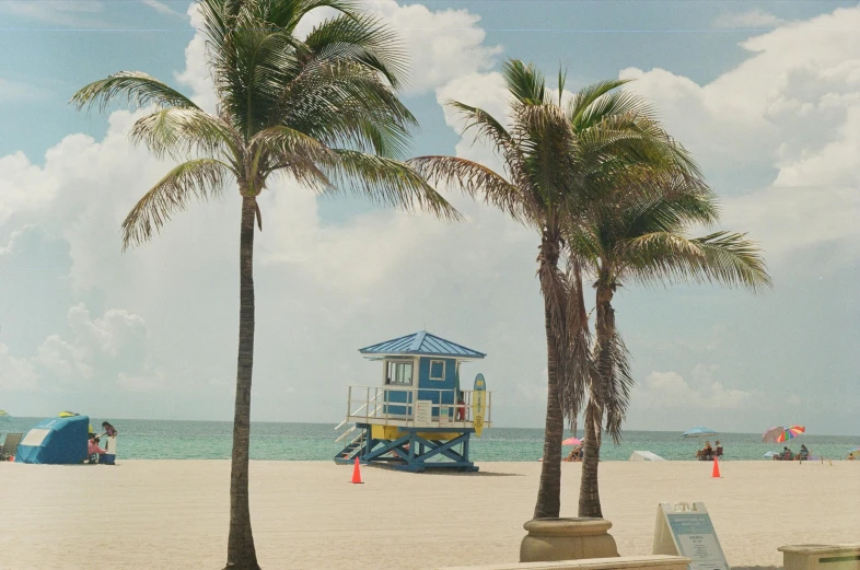 people playing in the sand at a beach with a lifeguard