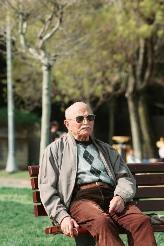 a man with glasses is sitting on a wooden bench