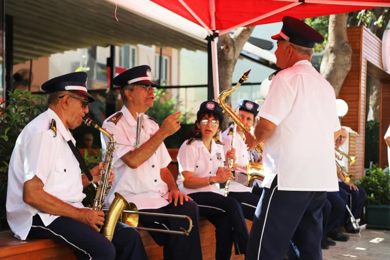 some people wearing uniforms are holding musical instruments