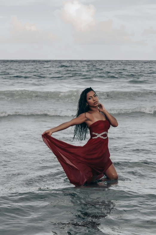 a woman is standing in the ocean waves