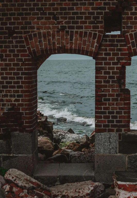 two archways leading to the ocean with a cloudy sky