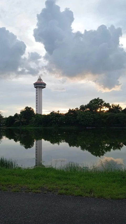 a small lake with water tower in the background