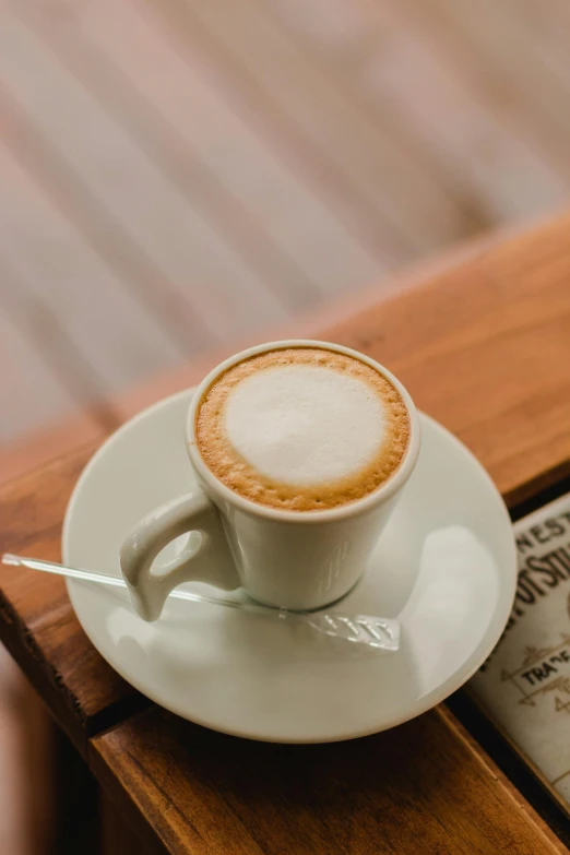 a white plate with a cup on it on top of a table