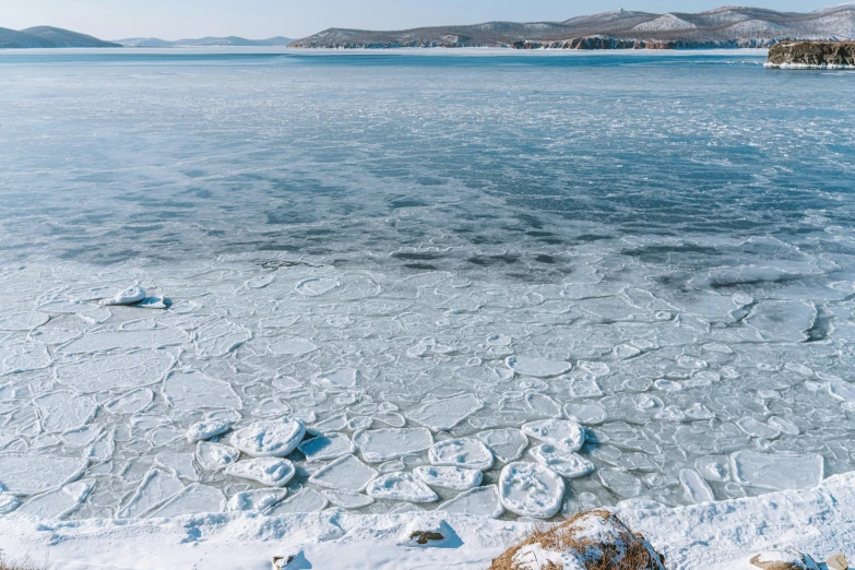 a blue lake and ice floes in the distance