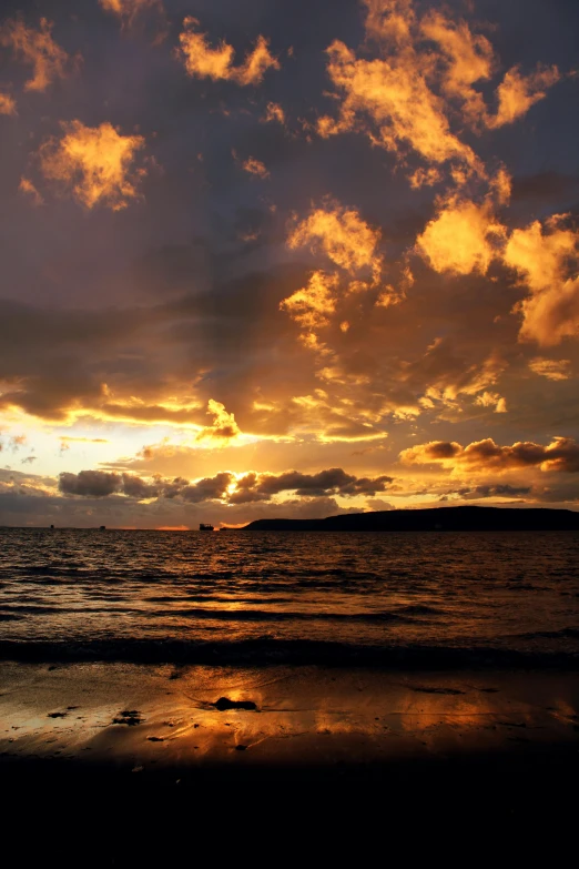 a sunset with a lone wave coming towards the shore