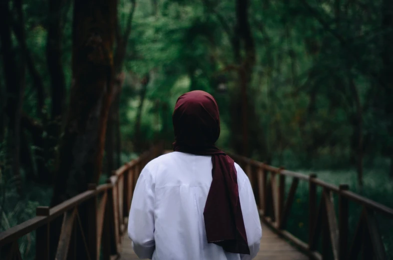 a woman in white shirt walking on a bridge