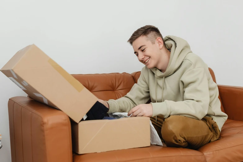 a man sitting on a couch with a box over his knee