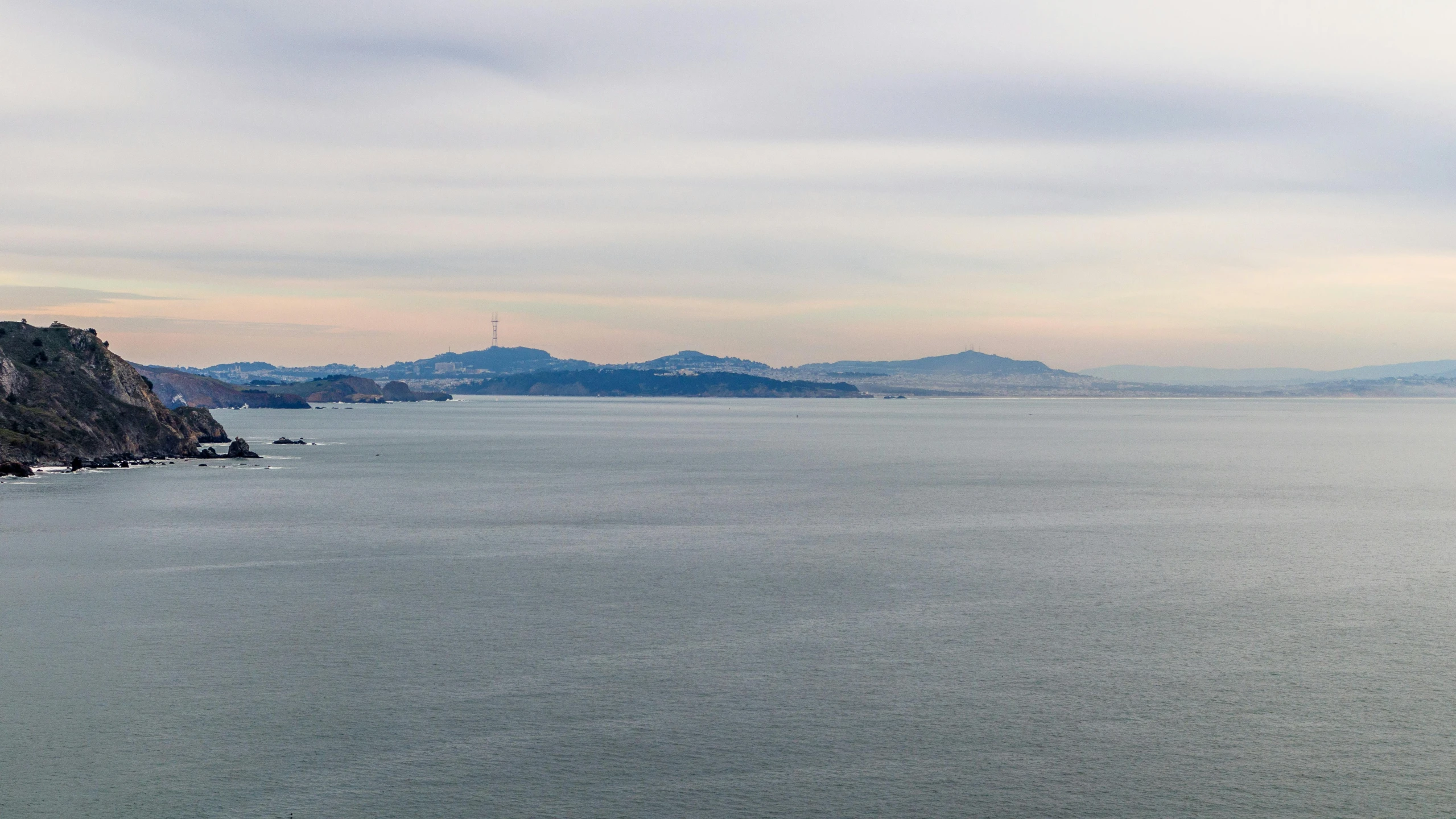 water with rocks, two hills and one distant sky