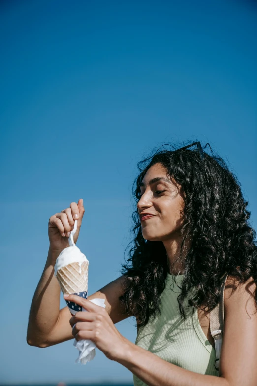 a girl holding an ice cream cone in her hand