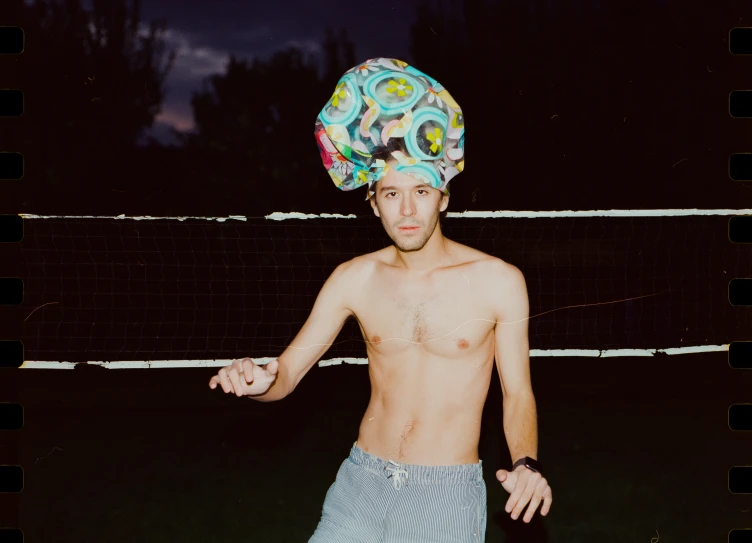 young man wearing a swim cap and without shirt and standing on a beach