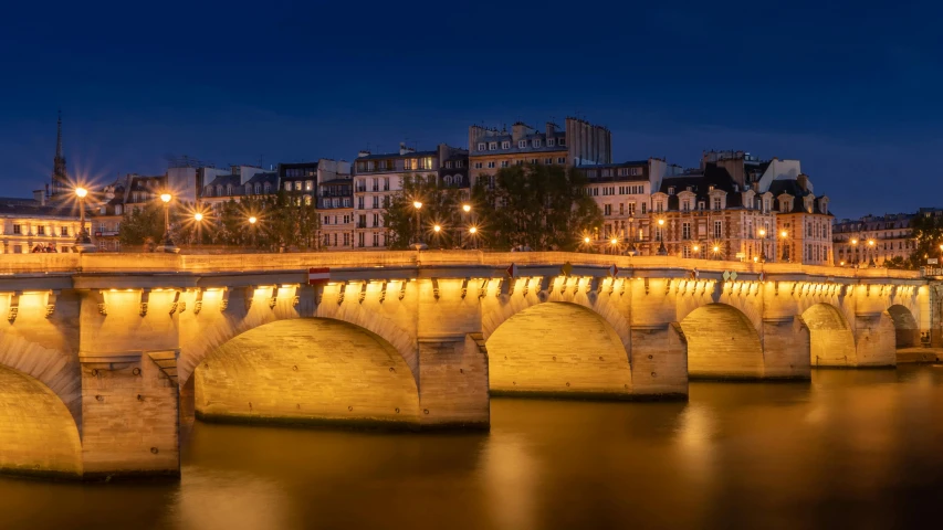 a city lit up at night, with a bridge