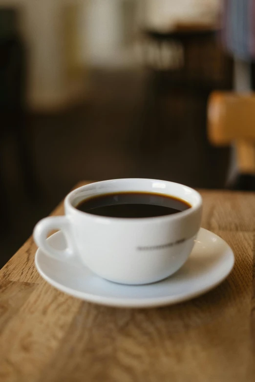 a cup of coffee and some sort of sauce on a table